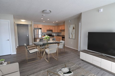 a living room and kitchen with a table and chairs