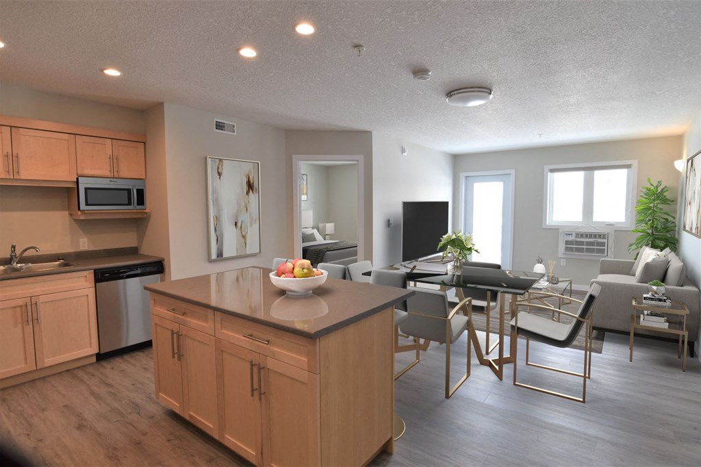 an open kitchen and living room with a dining room table and chairs and a kitchen