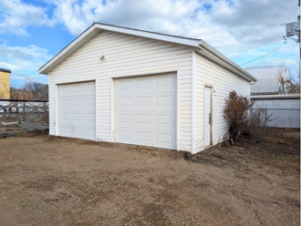 a small white garage with a white garage door
