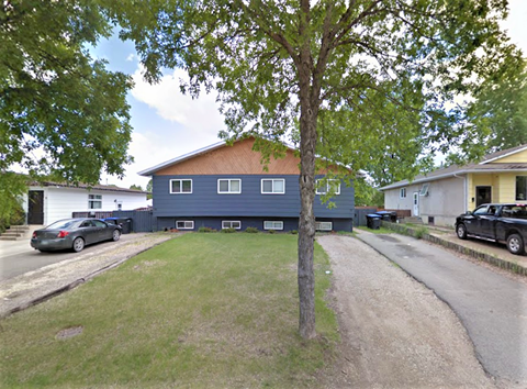 a blue house with a tree in front of it