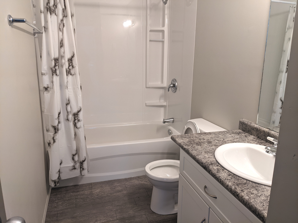 a small bathroom with a shower toilet and sink