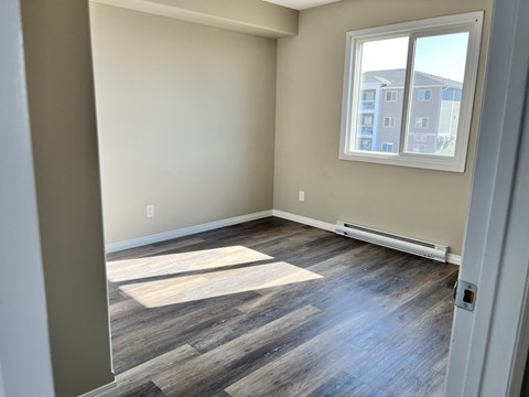 an empty room with wood floors and a window