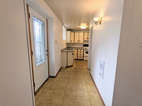 a view of a kitchen from the hallway of a home