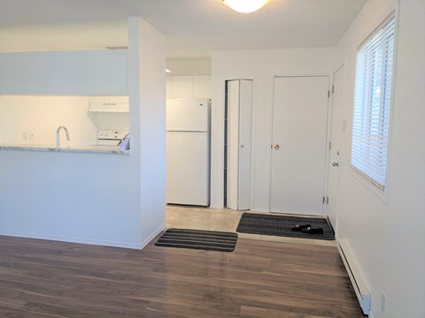 a kitchen with white walls and a door to a white refrigerator