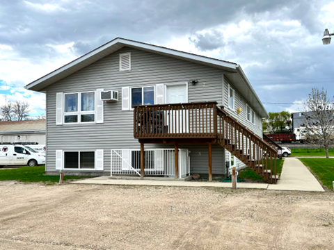 the front of a house with a deck and a driveway
