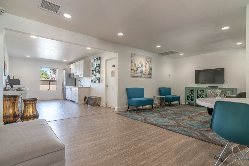 A living room with a grey couch and blue chairs.