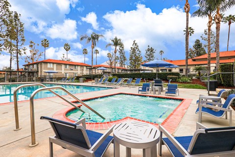 A pool and jacuzzi with a red pool ladder and blue pool chairs.
