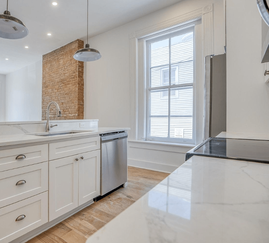a white kitchen with a sink and a window