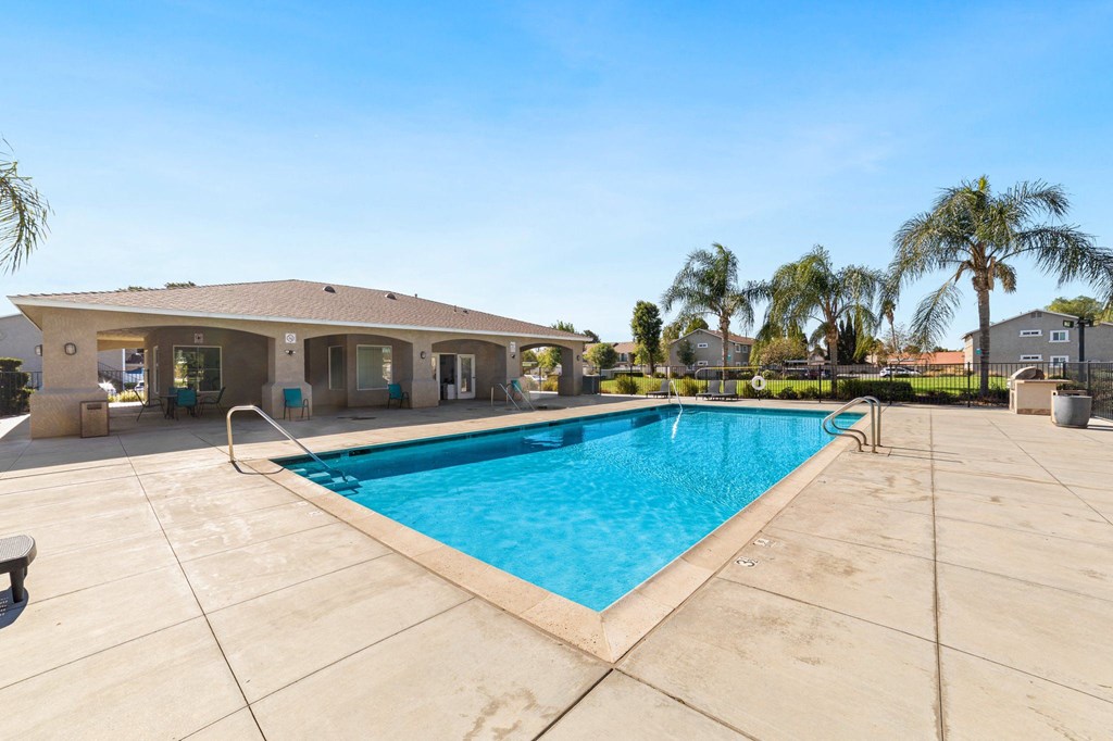 A swimming pool in a residential area with a house in the background.