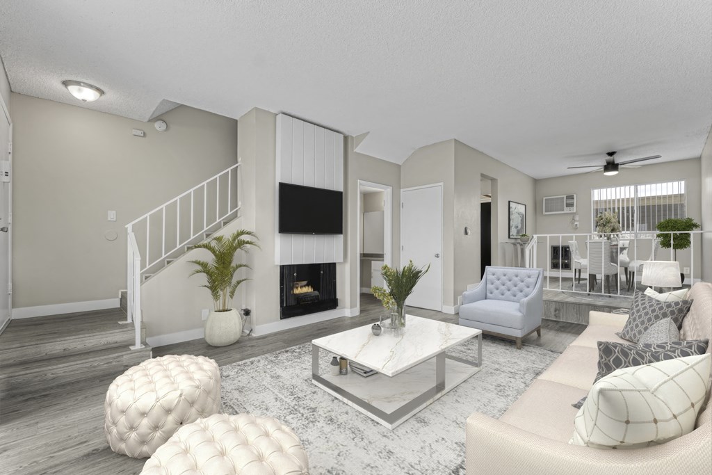 a living room with white furniture and a fireplace