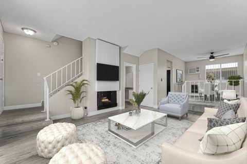 a living room with white furniture and a fireplace