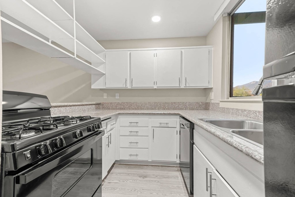 a kitchen with white cabinets and a black stove top oven