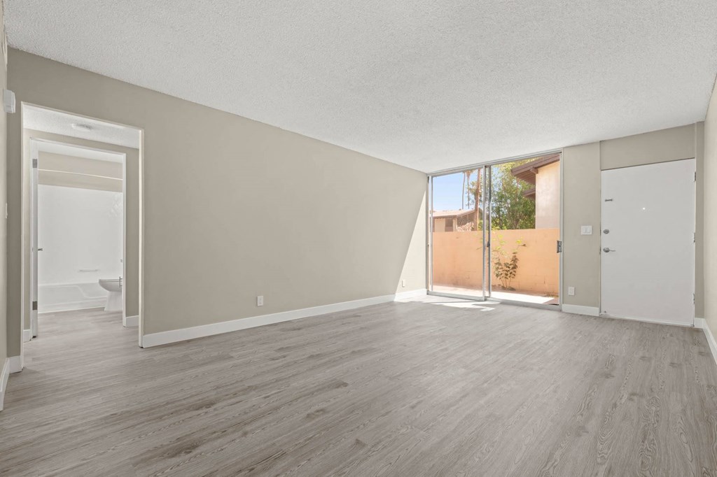 a bedroom with hardwood floors and a sliding glass door to a patio