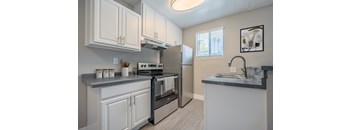 A kitchen with white cabinets and a black stove top oven.