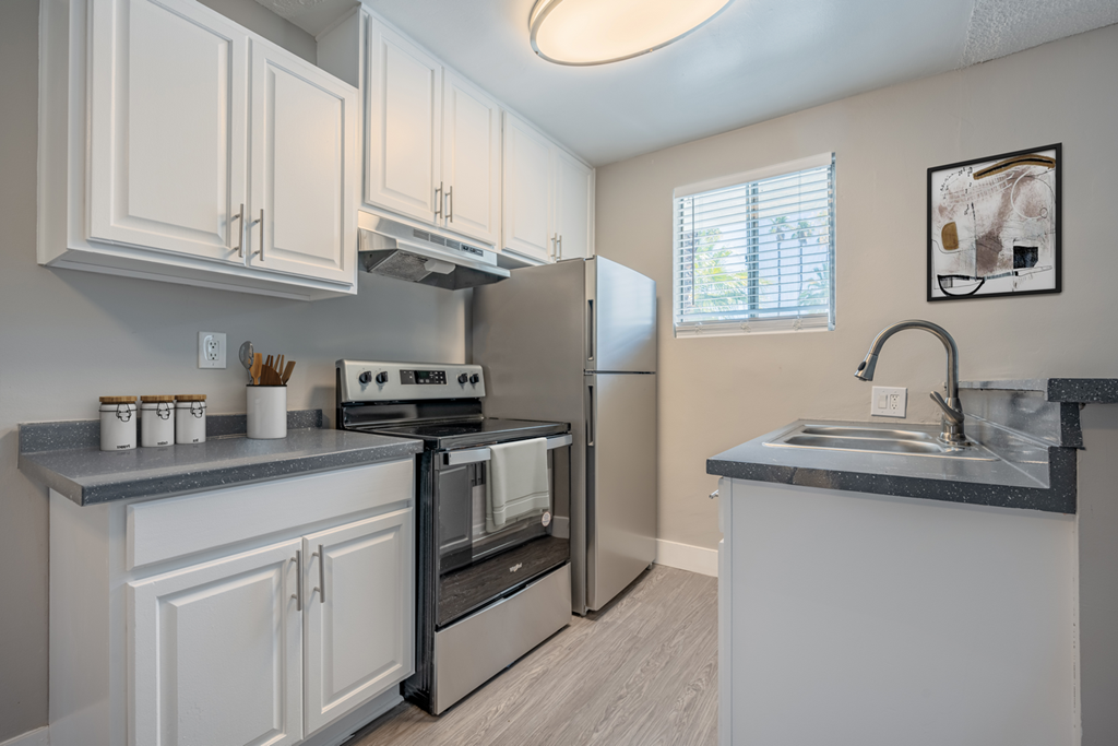 a kitchen with white cabinets and a sink and a refrigerator