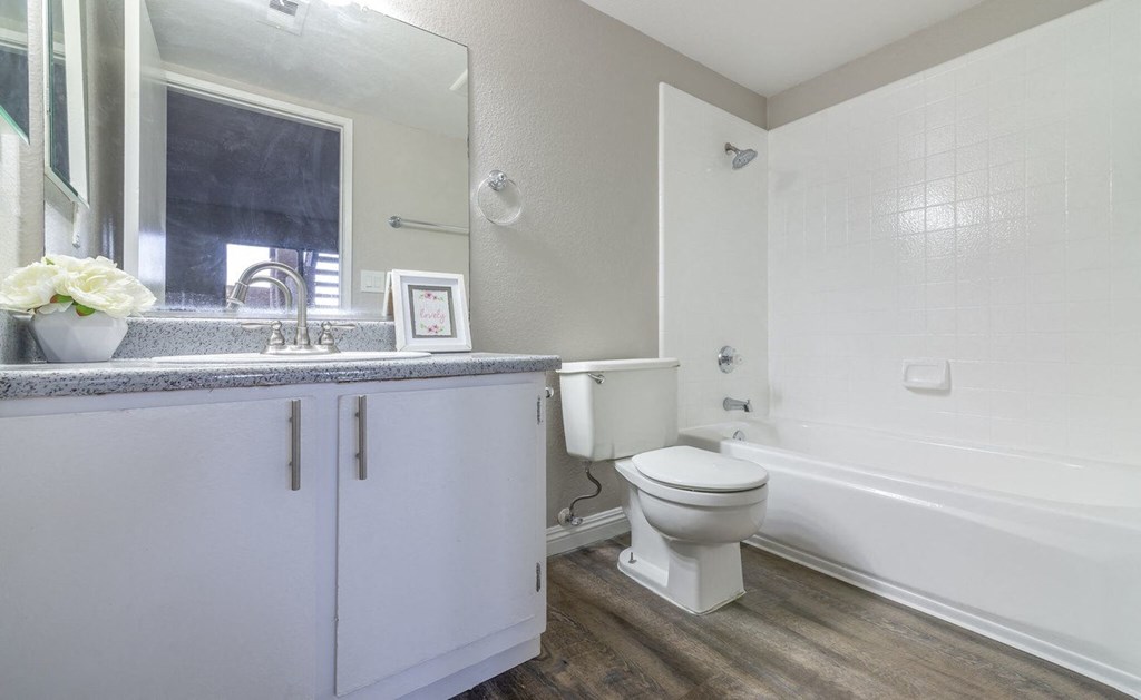 A white bathroom with a toilet, sink, and bathtub.