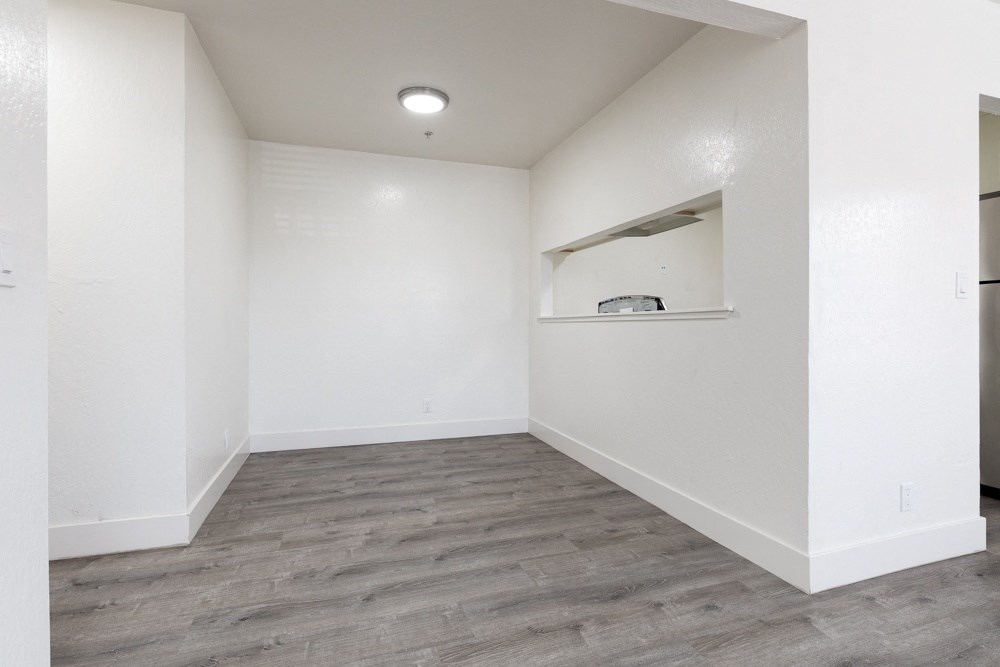 an empty room with white walls and a wood floor