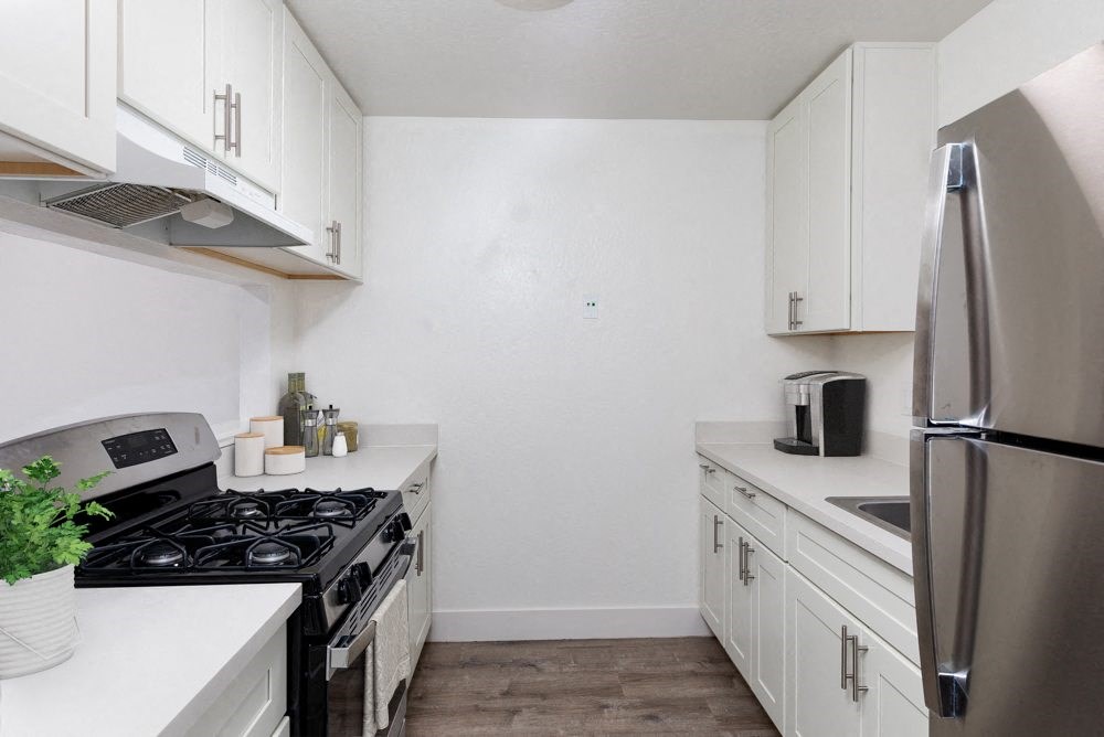 a white kitchen with stainless steel appliances and white cabinets