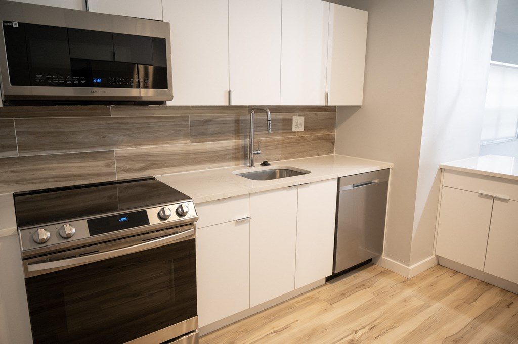 a kitchen with white cabinets and stainless steel appliances and a sink