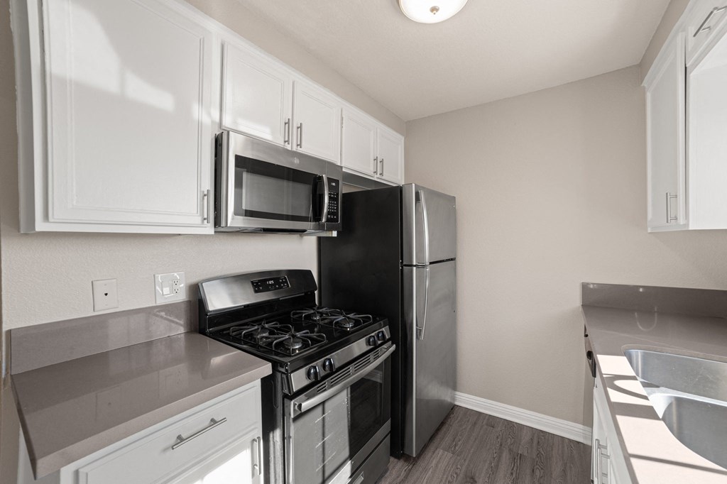A kitchen with white cabinets and stainless steel appliances.