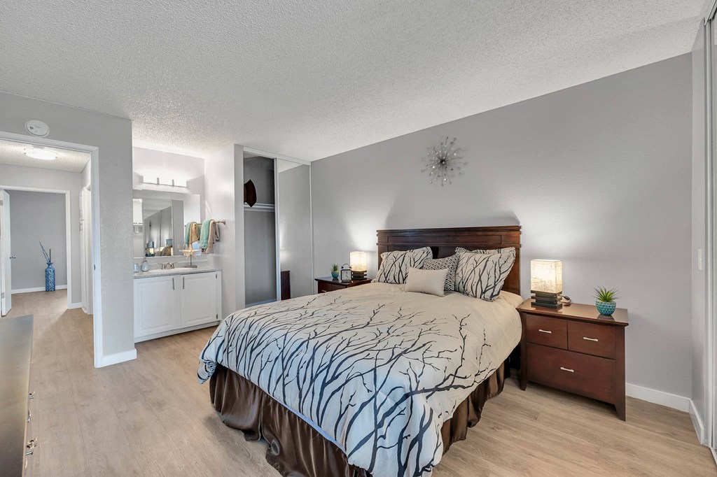 a bedroom with a large bed and a bathroom with a sink