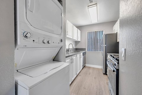 a white kitchen with a washer and dryer in it