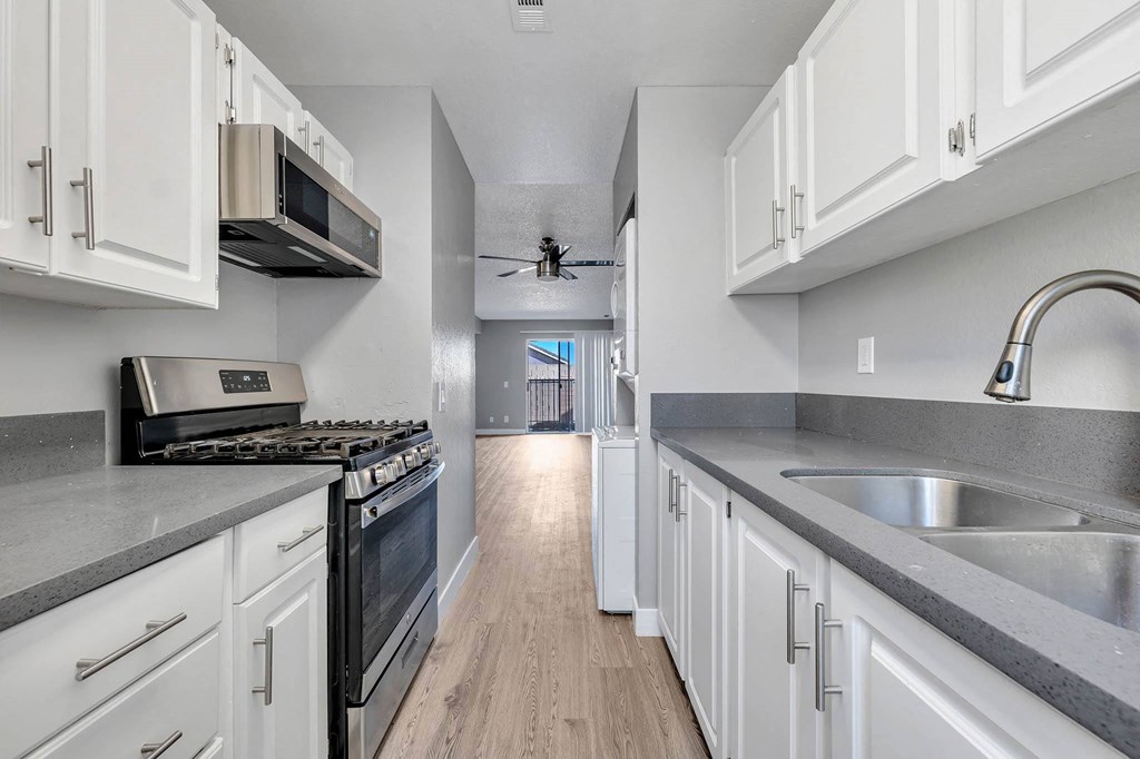 a kitchen with white cabinets and stainless steel appliances