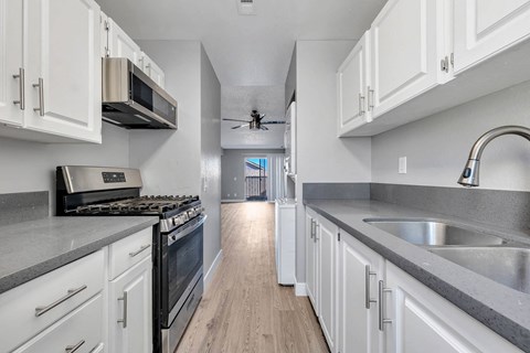 a kitchen with white cabinets and stainless steel appliances