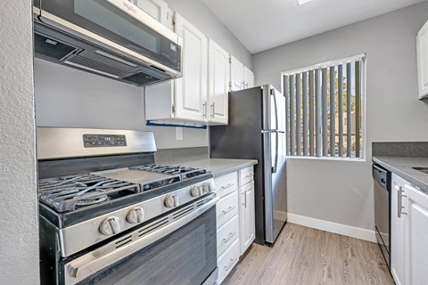 a kitchen with stainless steel appliances and white cabinets