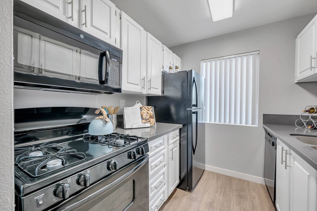 a kitchen with stainless steel appliances and white cabinets