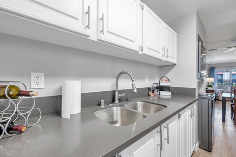 a kitchen with a sink and white cabinets