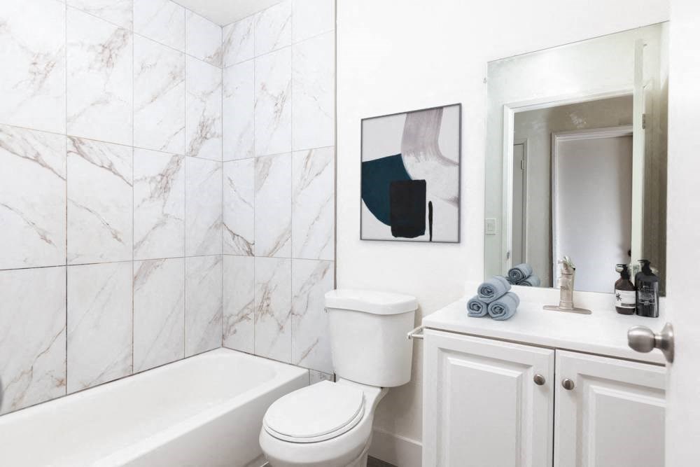 a white bathroom with a tub and a toilet