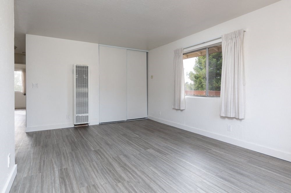 an empty living room with white walls and a window