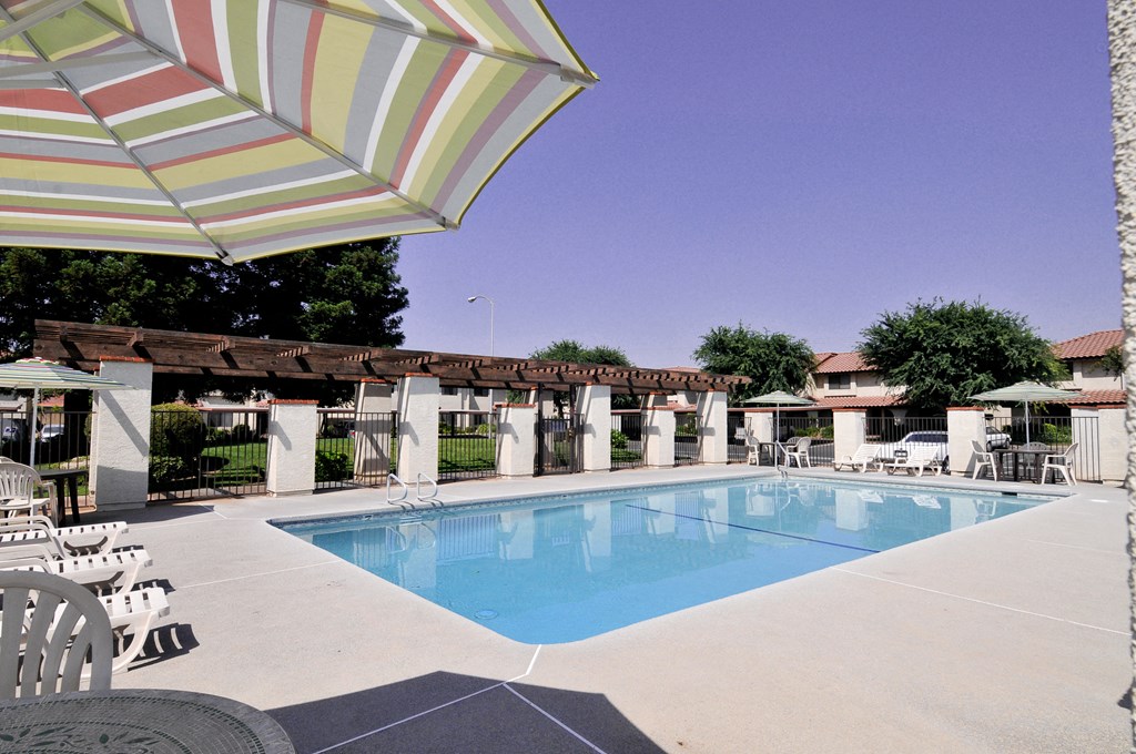 a swimming pool with umbrellas and chairs around it at the resort