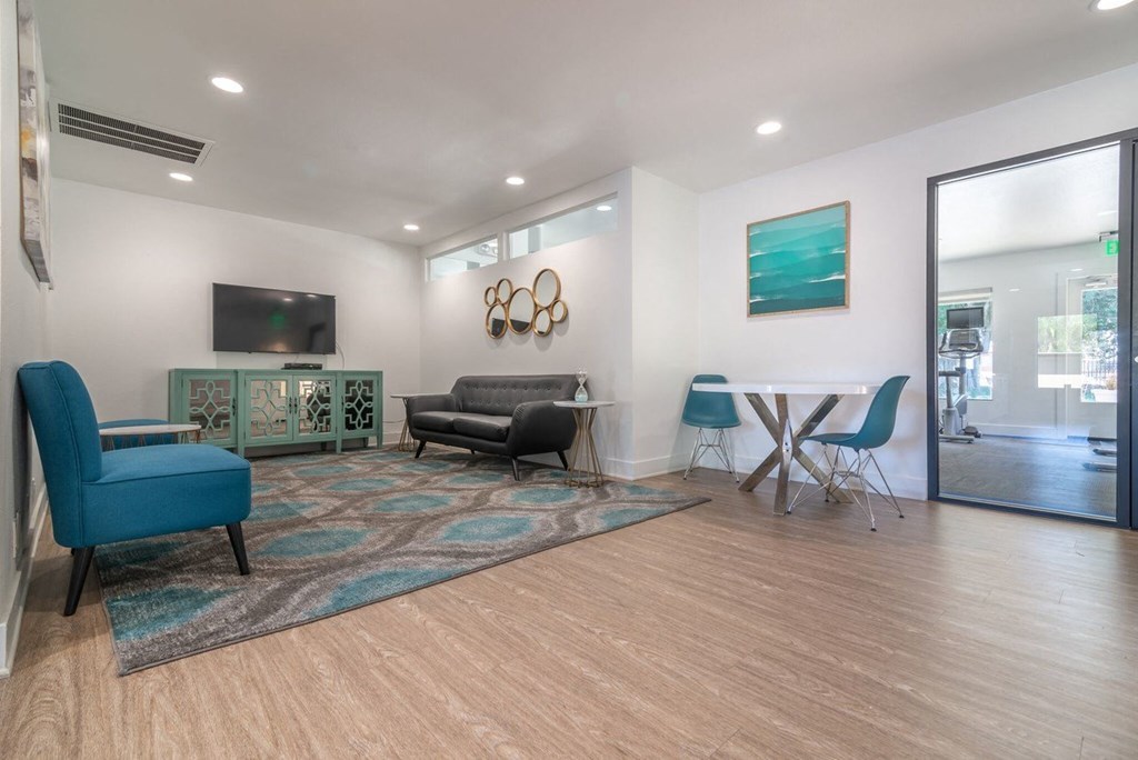 A living room with a blue chair and a grey couch.