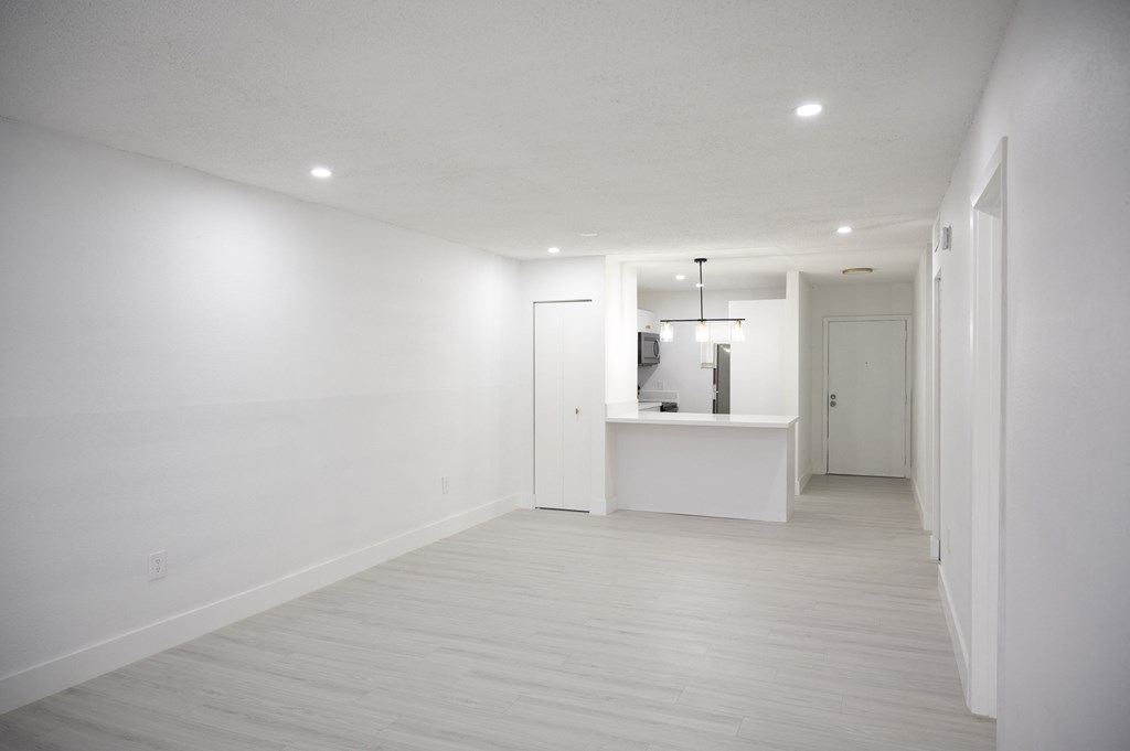 an empty hallway in a home with white walls and a white counter