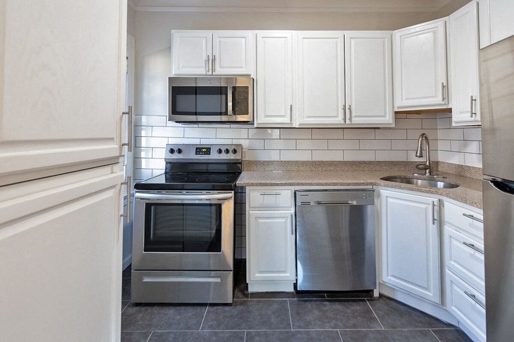a kitchen with stainless steel appliances and white cabinets