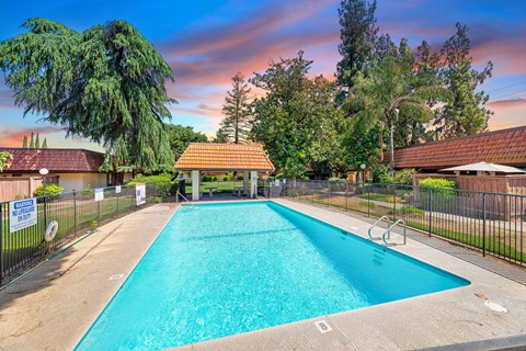 a swimming pool with a fence and a house with a pool