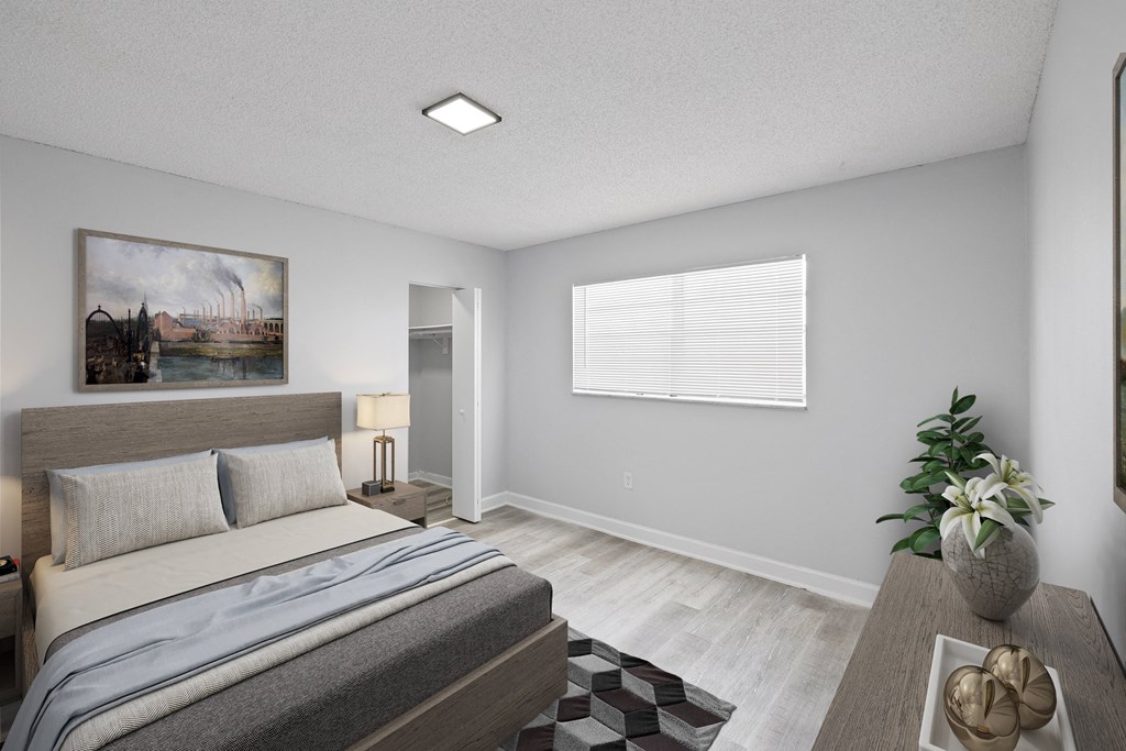 a bedroom with a large bed and a table with a plant on it