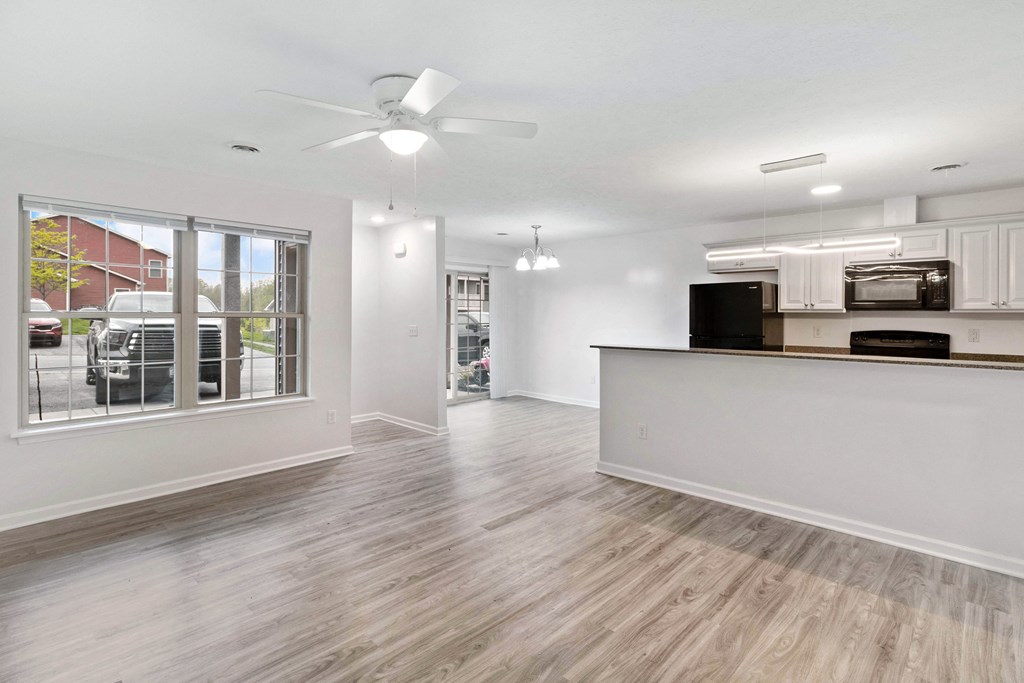 a living room and kitchen area with a large window