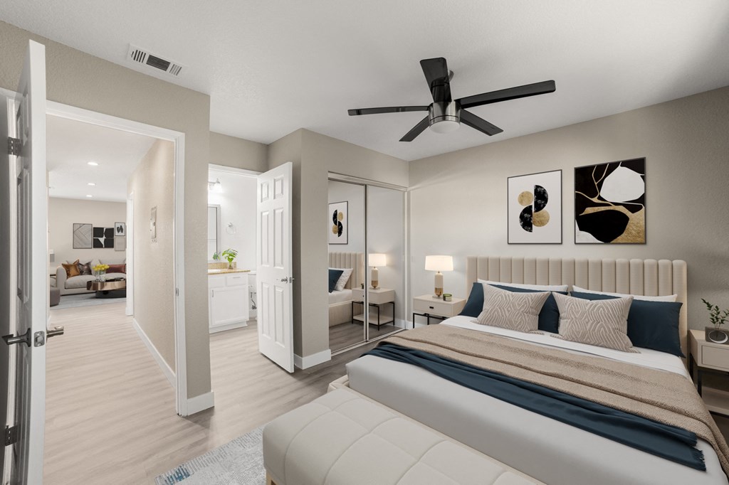 A bedroom with a large bed and a ceiling fan.