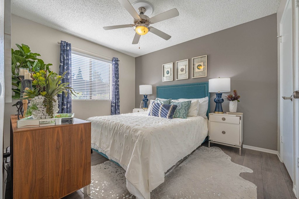 a bedroom with a bed and a ceiling fan