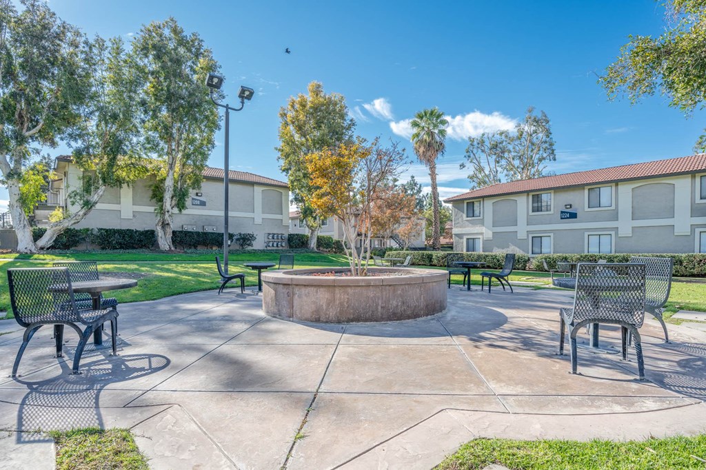 a large patio with tables and chairs and a fountain