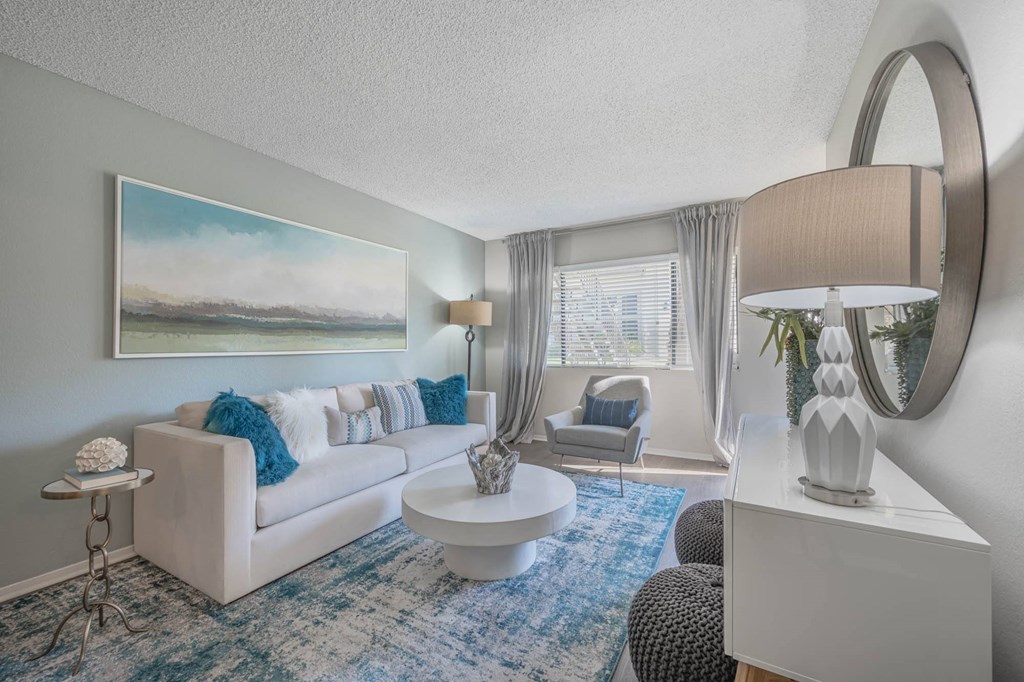 a living room with a white couch and a blue rug