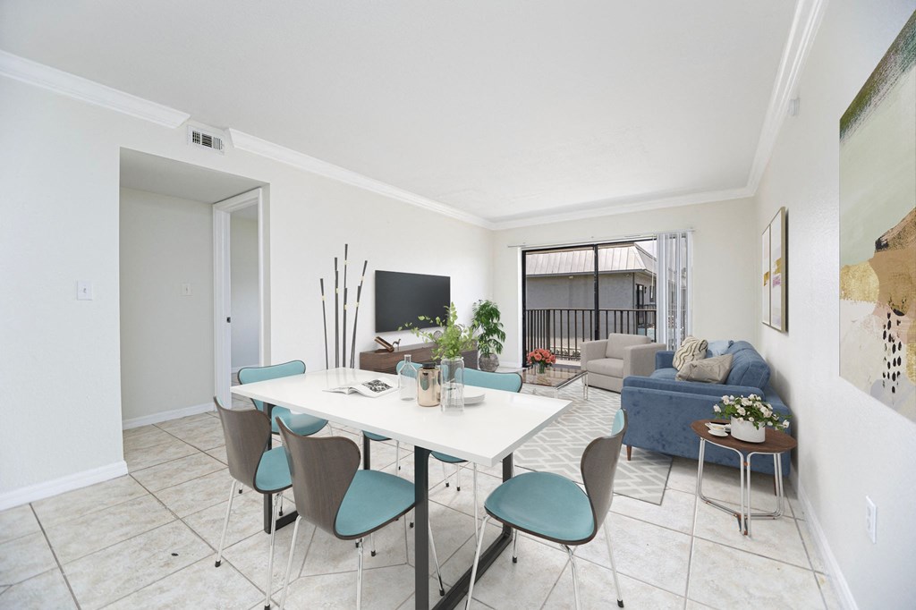 a living room with a white table and chairs and a blue couch in the background