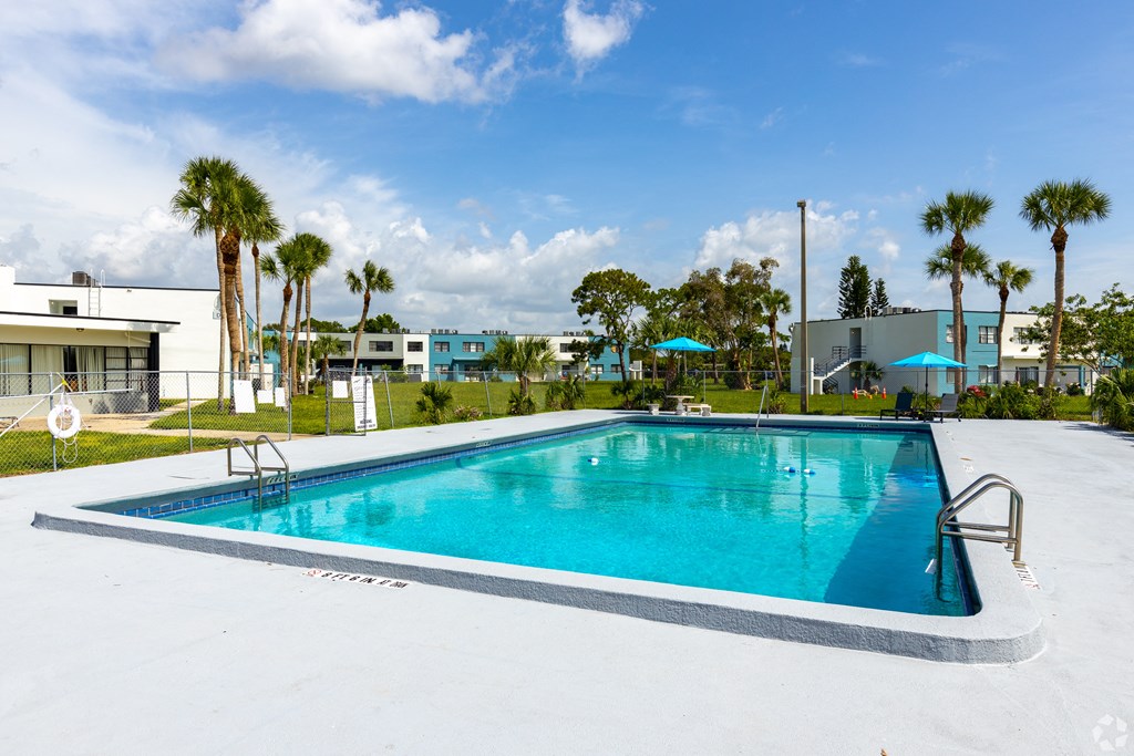 a large swimming pool with palm trees in the background