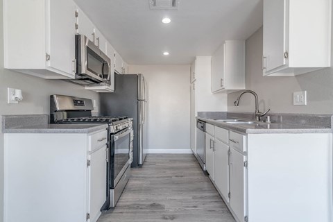 A kitchen with white cabinets and stainless steel appliances.