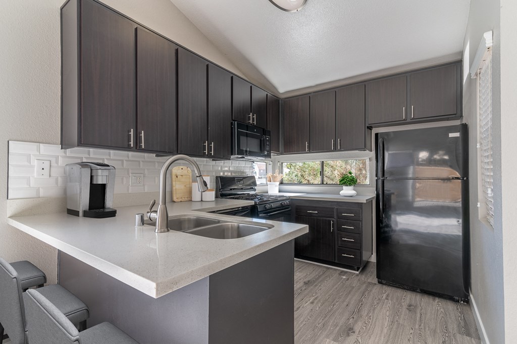 a kitchen with stainless steel appliances and black cabinets