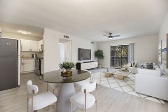 a living room and kitchen with white walls and wood floors