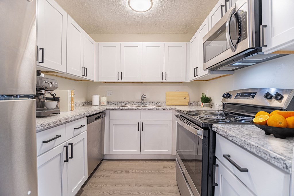 a kitchen with white cabinets and granite countertops